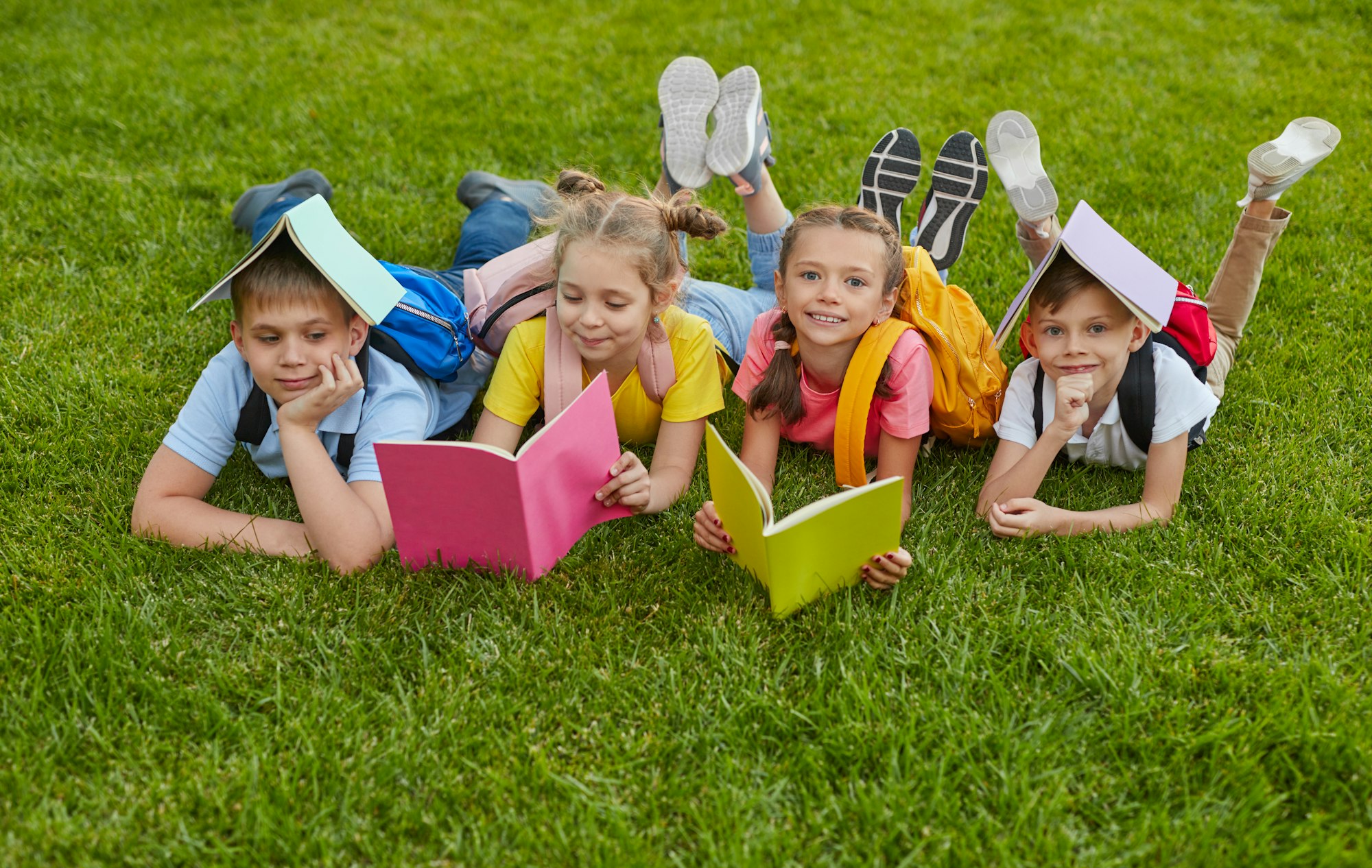 Preteen students with books in park