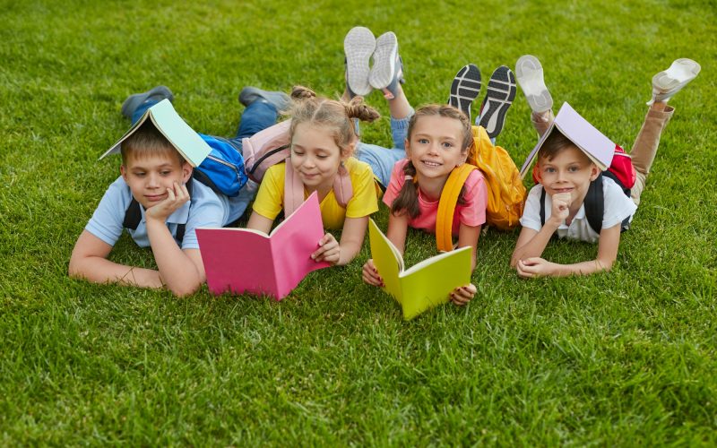 Preteen students with books in park